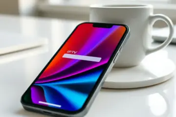alt_text: An iPhone on a desk shows a colorful streaming app with a buffering icon, bathed in soft morning light next to a coffee mug.